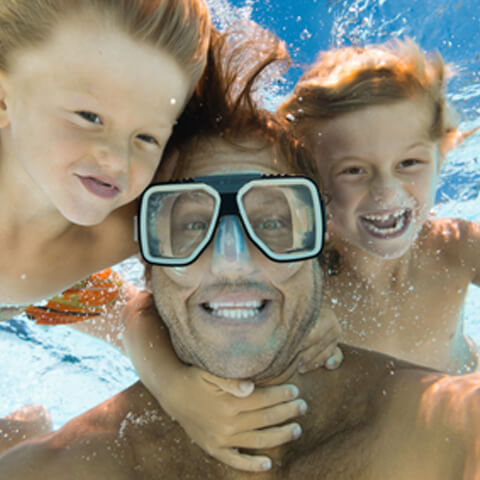 Children and adult holding breath underwater
